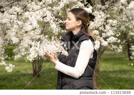 Happy thirty-year-old woman in cherry blossom orchard Happy thirty-year-old woman in cherry blossom orchard 113813698