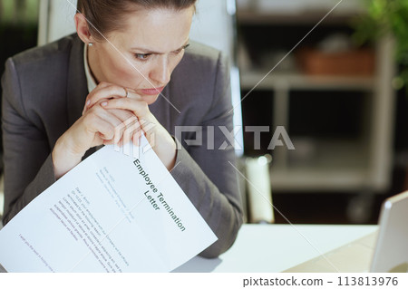 pensive modern female worker in modern green office 113813976