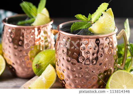 .Moscow mule cocktail served with ice and lime slice on wooden table .Moscow mule cocktail served with ice and lime slice on wooden table 113814346