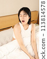 一個女人在床上睡覺、醒來、打哈欠 113814578