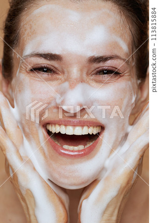 happy modern female with foaming facial cleanser washing face happy modern female with foaming facial cleanser washing face 113815884