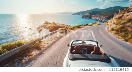 Classic car driving on a coastal road at sunset 113816415