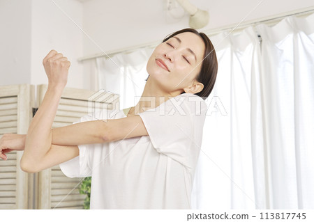 Woman stretching her arms at home Woman stretching her arms at home 113817745
