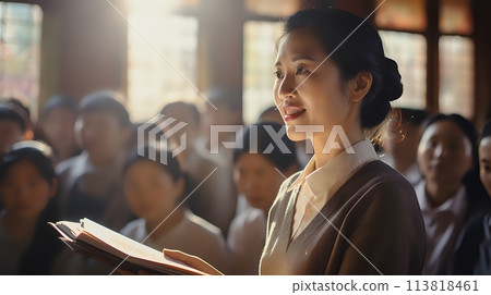 A young woman is speaking to a group of people 113818461