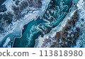 A river flowing through a snowy forest from an aerial view 113818980