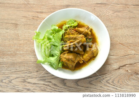 spicy fried pork bone with curry with fresh green oak salad on plate 113818990