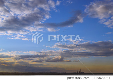 CHP and other plants stand on the shore of the lake in the evening at dusk under the evening sky 113820084