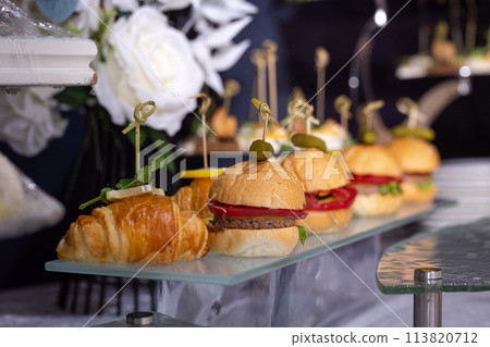 burgers on a stand on the buffet table 113820712