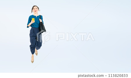 Full body photo of a white woman jumping while looking at her smartphone Full body photo of a white woman jumping while looking at her smartphone 113820833