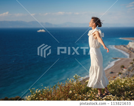 Beautiful Asian young woman in white dress outdoor in flower field under Rhodes city and above sea during sunset. embracing fresh air and engaging in outdoor activities. strong wind - element of Beautiful Asian young woman in white dress outdoor in flower field under Rhodes city and above sea during sunset. embracing fresh air and engaging in outdoor activities. strong wind - element of 113821633