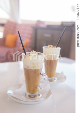 coffee is served in a tall glass glass with a straw. The concept of coffee drinks from the bar menu 113822156