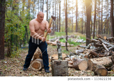 A strong man chopping wood. 113822236