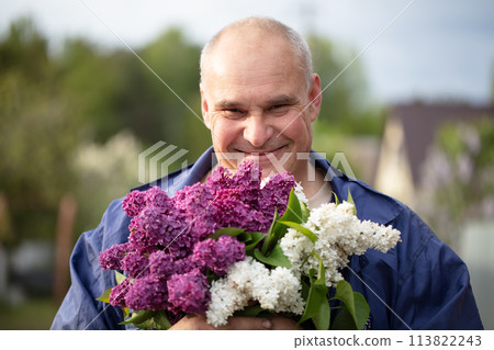 Elderly man with a bouquet of flowers. Brutal gray-haired man with a beautiful lilac. Elderly man with a bouquet of flowers. Brutal gray-haired man with a beautiful lilac. 113822243