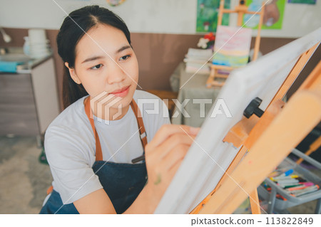 Art student drawing with watercolor painting on canvas doing some art projects on studio workshop 113822849