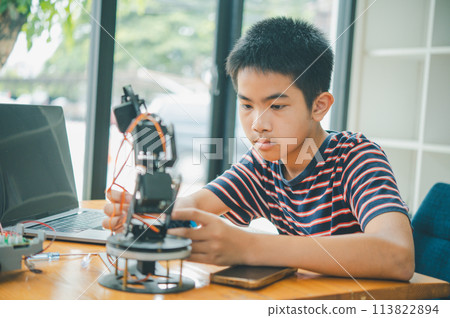 Asian boy learning and studying the work of technology robots.homeschool and science for tech project. playing childhood kids hobby leisure lifestyle people toys robotics technology. 113822894