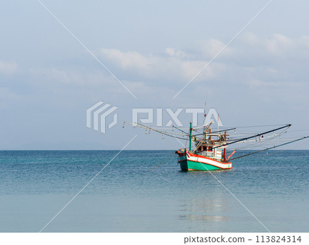 Fishing boat anchored against a clear sky Fishing boat anchored against a clear sky 113824314