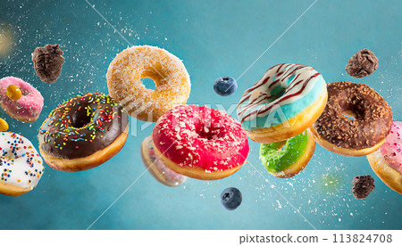 Colorful doughnuts in motion on blue background 113824708