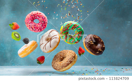 Colorful doughnuts in motion on blue background 113824709
