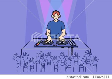 Man DJ performs in nightclub spinning records on mixing console, near partygoers hands Man DJ performs in nightclub spinning records on mixing console, near partygoers hands 113825111