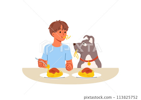 Little boy and dog eat spaghetti sitting at table, demonstrating friendship and trust 113825752