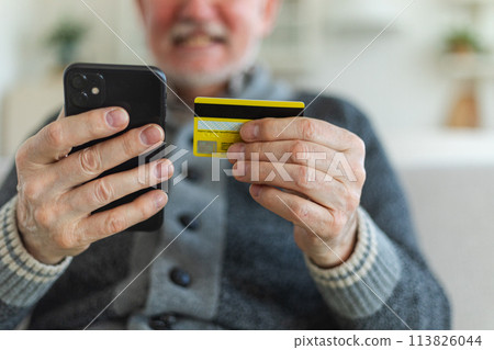 Senior man shopping online holding smartphone paying with credit card. Old grandfather buying on Internet enter credit card details. Online shopping delivery service Older generation modern tech usage 113826044
