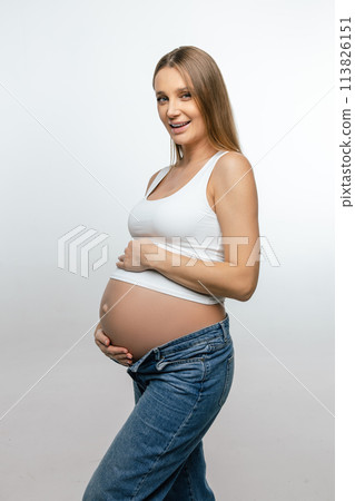 Smiling pregnant woman in jeans and white tshirt 113826151