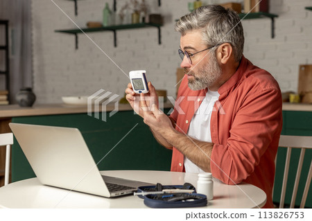 Online medical consultation for diabetic patient man with glucometer via laptop 113826753