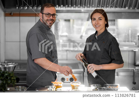 Experienced chef conducting a workshop for a new colleague 113826781