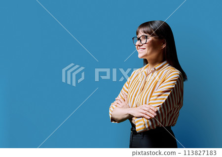 Profile portrait of mature confident smiling woman on blue background Profile portrait of mature confident smiling woman on blue background 113827183