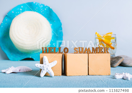 Concept hello summer text on cubes on a background of cocktail, hat and starfish 113827498
