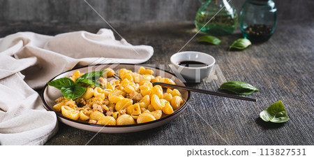 Delicious pasta with minced meat and basil on a plate on the table web banner Delicious pasta with minced meat and basil on a plate on the table web banner 113827531