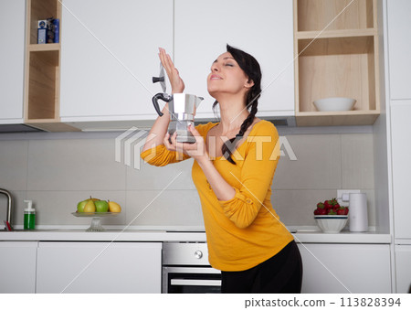 Happy Young woman showing moka pot Happy Young woman showing moka pot 113828394