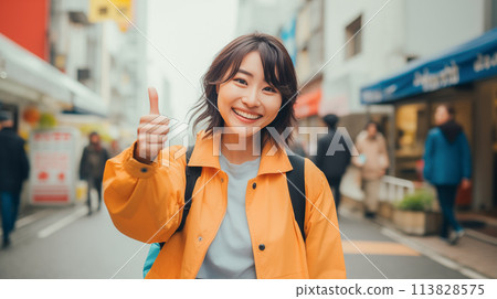 A woman giving a thumbs up on a street corner 113828575