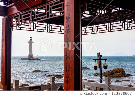 View of the lighthouse in the sea near the rocky shore. Heavenly Grottoes Park, Sanya, China View of the lighthouse in the sea near the rocky shore. Heavenly Grottoes Park, Sanya, China 113828602