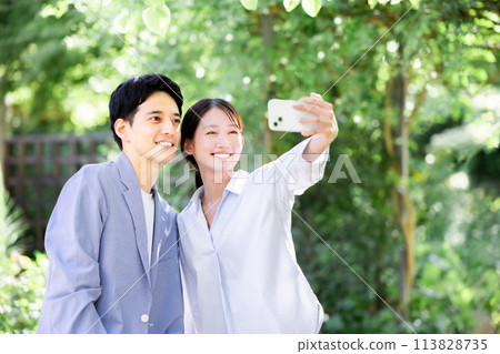 Couple taking a selfie in the park 113828735