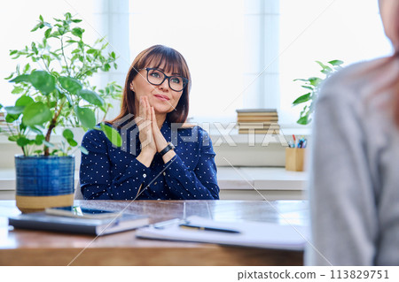 Mature sad woman in therapy session with mental professional 113829751