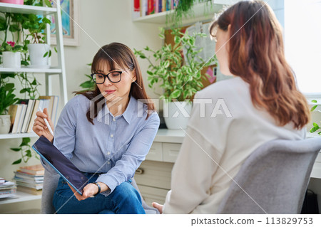 Professional mental therapist working with young woman, sitting together in office 113829753