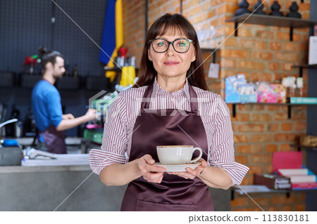 Woman in apron, food service coffee shop worker, small business owner with cup of coffee 113830181