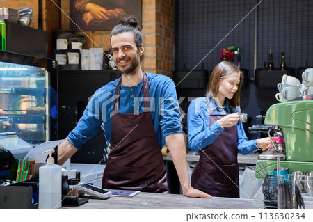 Colleagues partners young man and woman in aprons working together in coffee shop 113830234