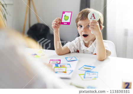 Child Learning Alphabet Cards at Table 113830381
