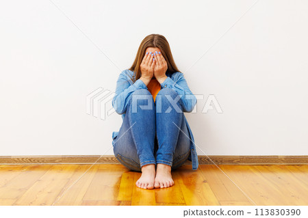 Woman Sitting on Floor Feeling Upset Woman Sitting on Floor Feeling Upset 113830390