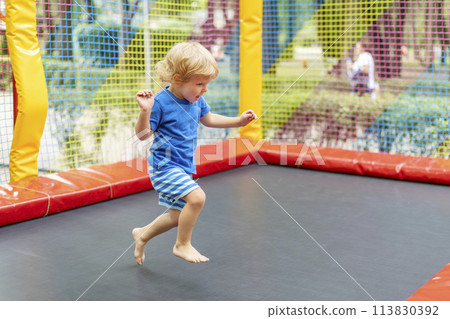 Toddler Jumping on Outdoor Trampoline 113830392