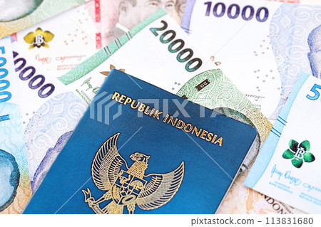 Indonesia passport and many indonesian rupiah currency money bills close up Indonesia passport and many indonesian rupiah currency money bills close up 113831680