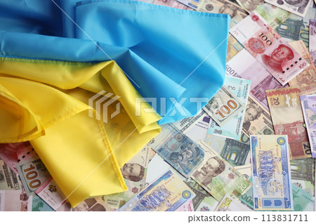 Ukrainian flag on many banknotes of different currency. Background of war funding and military support price in Ukraine Ukrainian flag on many banknotes of different currency. Background of war funding and military support price in Ukraine 113831711