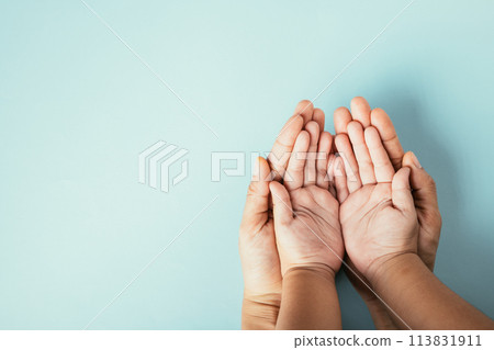 Top view studio shot of family hands stacked on an isolated background. Parents and child holding empty space symbolizing support on Family and Parents Day. Top view studio shot of family hands stacked on an isolated background. Parents and child holding empty space symbolizing support on Family and Parents Day. 113831911