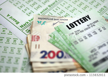 Green lottery tickets and ukrainian money bills on blank with numbers for playing lottery close up 113832011
