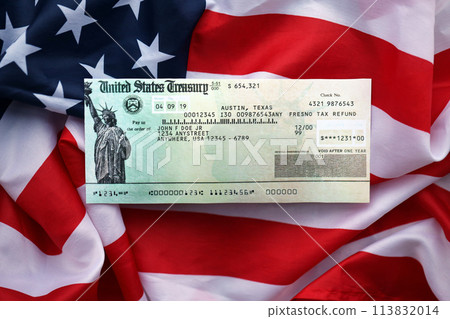 United States Treasury Refund check on waving American Flag close up. 113832014