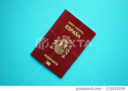Red Spanish passport of European Union on blue background close up. Tourism and citizenship concept Red Spanish passport of European Union on blue background close up. Tourism and citizenship concept 113832036