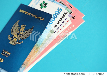 Blue Republic Indonesia passport with money and airline tickets on blue background close up. Tourism and travel concept 113832064