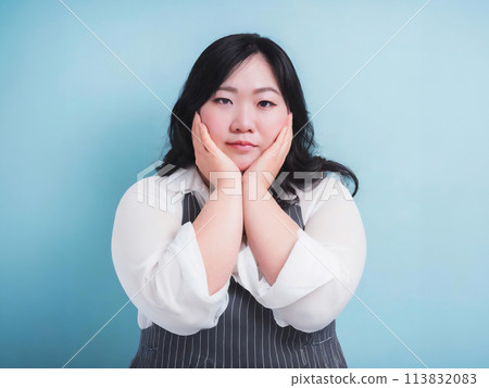 Chubby woman with hand on cheek 113832083